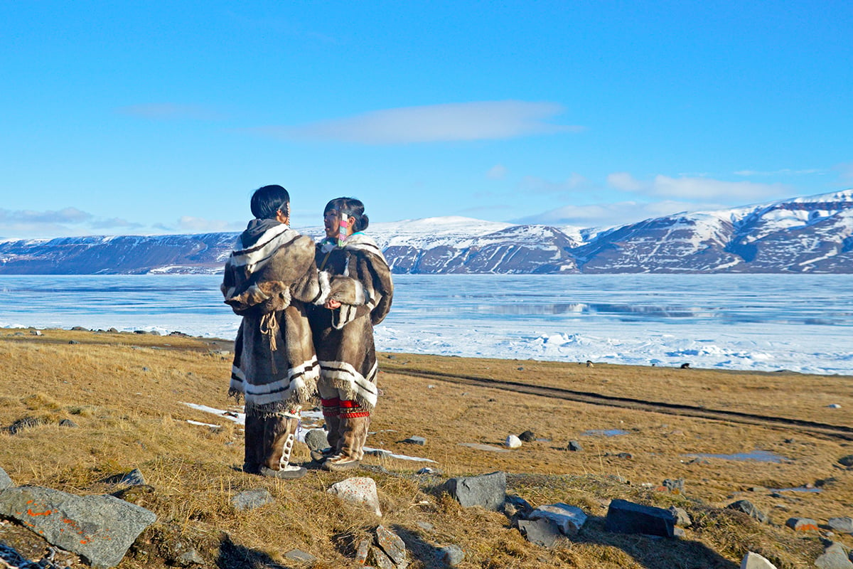 3-Ultimate-Journey-Midnight-Sun-Carousel-1-Inuit-Throat-singers-in-front-of-mountains-Private-Journey-Arctic-Polar-Adventure-Arctic-Kingdom-1